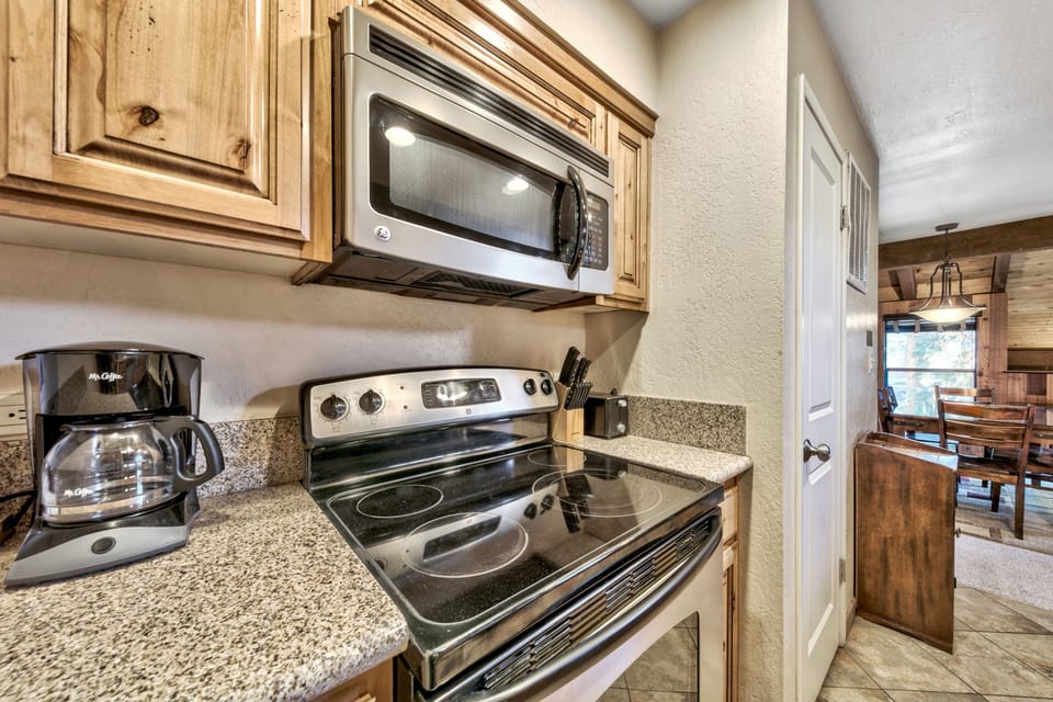Your fully equipped kitchen features granite counters, stainless steel appliances, and warm wood cabinets—perfect for preparing home-cooked meals during your stay.