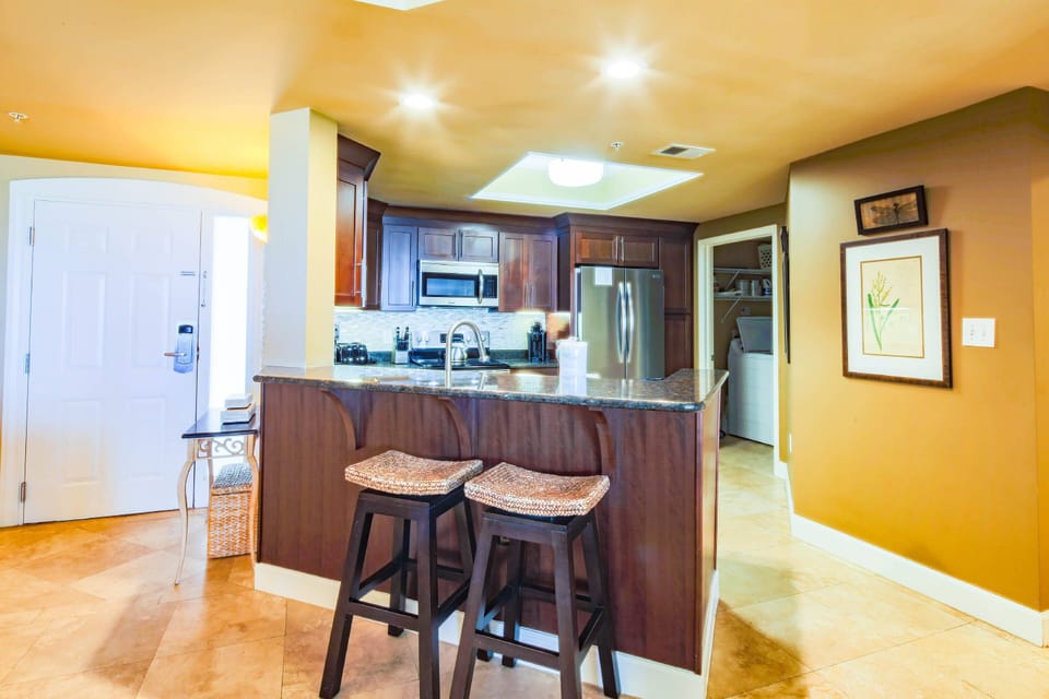 There are two stools on the dining area side of the kitchen counter.
