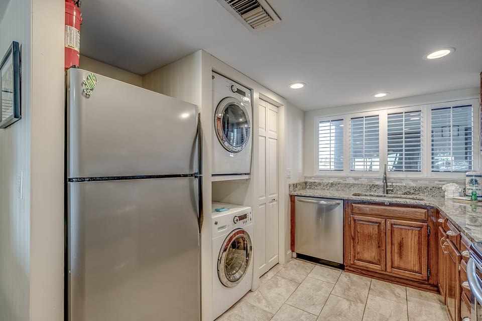 Kitchen has stainless appliances plus a stackable washer/dryer