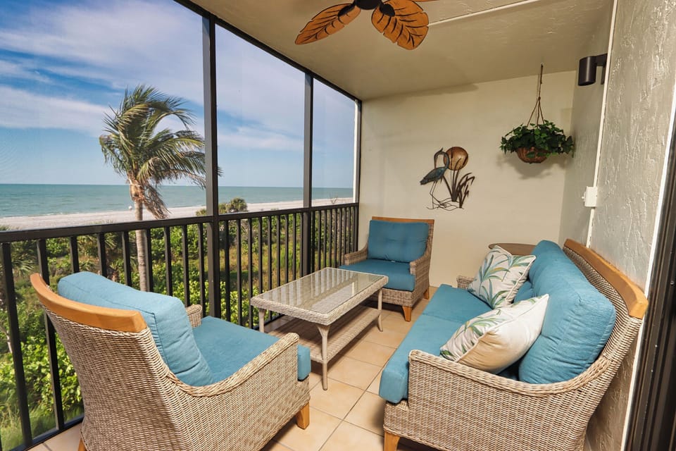 Screened lanai with seating and beach view