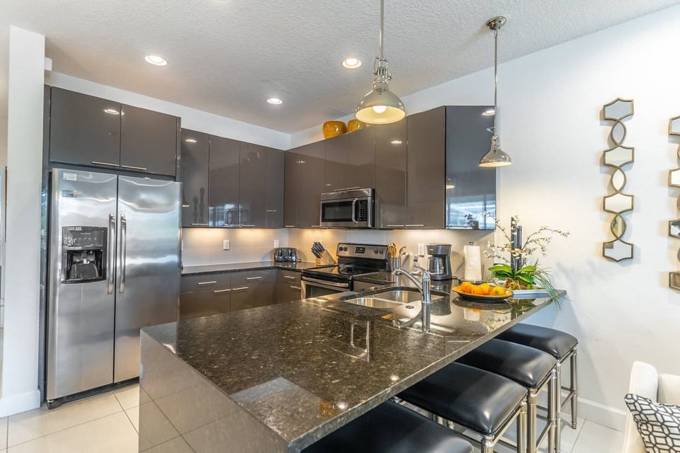 Modern Kitchen w/Stainless Steel Appliances and Waterfall Granite Countertops - bar seating for 4