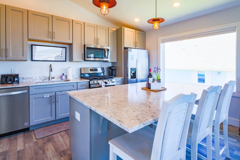 The beautiful kitchen features a central island, granite countertops and stainless steel appliances.