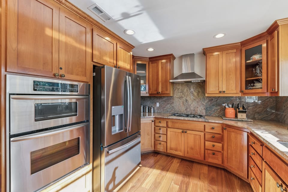 Step into your gourmet kitchen with warm cherry cabinets, granite counters, and premium stainless appliances—perfect for creating memorable meals.