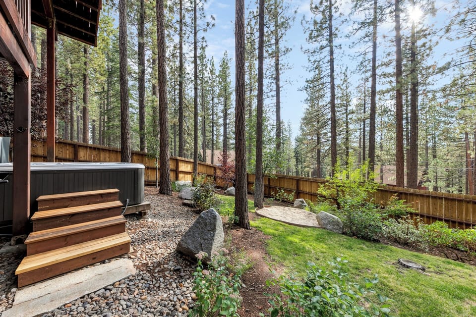 Step into your private forest sanctuary, complete with a relaxing hot tub surrounded by towering trees and natural landscaping.
