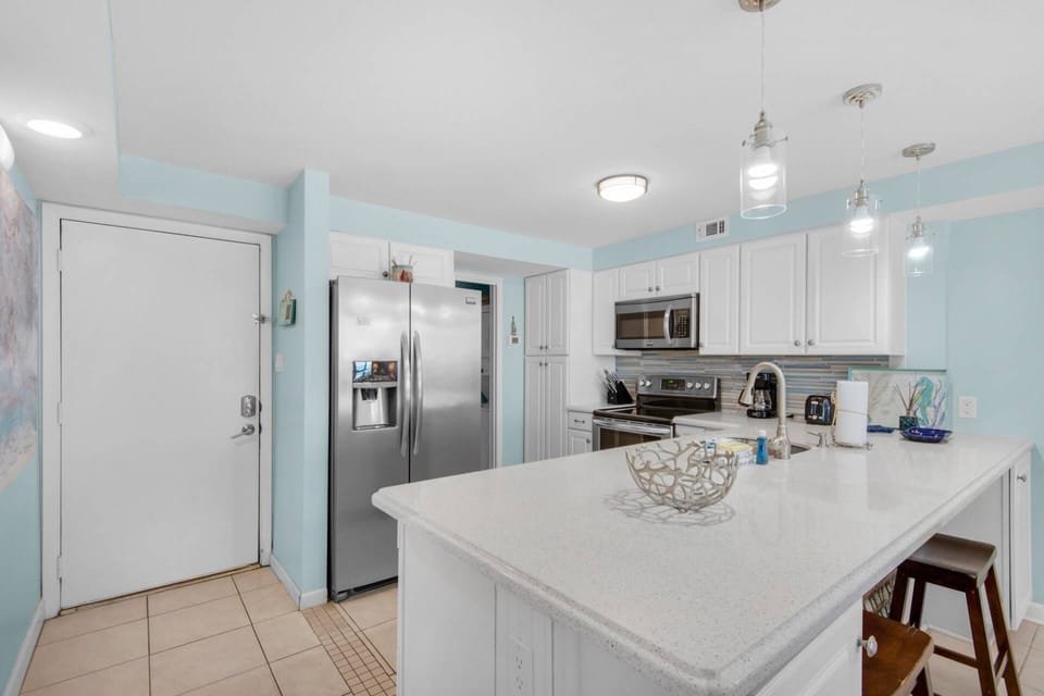 The kitchen is fully stocked and equipped with stainless steel appliances.