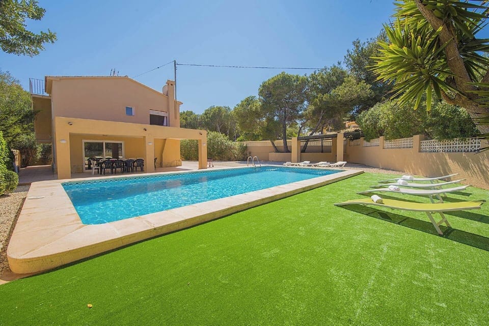 Angenehme Sommervilla mit privatem Pool in Moraira (Costa Blanca) für 14 Personen, mit sieben Schlafzimmern und vier Badezimmern, auf zwei unabhängige Etagen, welche durch Außentreppen verbunden sind.INNENAUSSTATTUNG: Diese Villa besteht aus dem ERDGESCHOSS, in dem sich ein Wohn-Esszimmer mit Zugang zur überdachten Terrasse und zum Pool befindet. Eine voll ausgestattete Küche mit Gasherd und Geschirrspüler. Drei Schlafzimmer, zwei davon mit je zwei Einzelbetten und eines mit einem Doppelbett. Auch gibt es zwei Badezimmer, eines mit Badewanne und das andere mit Dusche. Im OBERGESCHOSS gibt es ein Wohn-Esszimmer mit SAT TV/TDT, vier Schlafzimmer, zwei davon mit je zwei Einzelbetten und zwei mit je einem Doppelbett. Ein Badezimmer mit Badewanne und schließlich ein Badezimmer mit Dusche.AUSSENBEREICH: Großes Grundstück mit einem 10x5 Pool mit Metalltreppe und viel Platz um in den Liegen die Sonne zu geniessen. Es gibt auch einen überdachten Grill um Mahlzeiten im Freien einzunehmen und Parkplatz auf demselben Grundstück für vier Fahrzeuge.LAGE: Nur 900 m bis zum Sandstrand von Moraira und 700 m zu den nächsten Restaurants. Der nächste Supermarkt ist in 1,5 km erreichbar, ebenso das Stadtzentrum von Moraira. Calpe ist 13 km entfernt.BEMERKUNGEN: Es gibt kein Internet. Haustiere bis 12 kg sind gegen Aufpreis erlaubt.