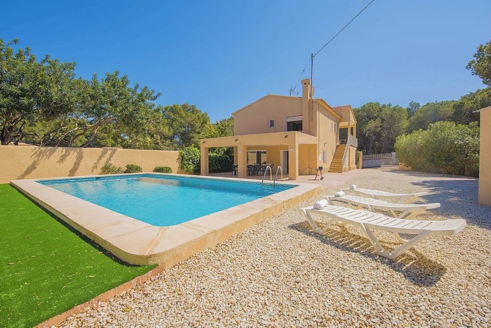 Angenehme Sommervilla mit privatem Pool in Moraira (Costa Blanca) für 14 Personen, mit sieben Schlafzimmern und vier Badezimmern, auf zwei unabhängige Etagen, welche durch Außentreppen verbunden sind.INNENAUSSTATTUNG: Diese Villa besteht aus dem ERDGESCHOSS, in dem sich ein Wohn-Esszimmer mit Zugang zur überdachten Terrasse und zum Pool befindet. Eine voll ausgestattete Küche mit Gasherd und Geschirrspüler. Drei Schlafzimmer, zwei davon mit je zwei Einzelbetten und eines mit einem Doppelbett. Auch gibt es zwei Badezimmer, eines mit Badewanne und das andere mit Dusche. Im OBERGESCHOSS gibt es ein Wohn-Esszimmer mit SAT TV/TDT, vier Schlafzimmer, zwei davon mit je zwei Einzelbetten und zwei mit je einem Doppelbett. Ein Badezimmer mit Badewanne und schließlich ein Badezimmer mit Dusche.AUSSENBEREICH: Großes Grundstück mit einem 10x5 Pool mit Metalltreppe und viel Platz um in den Liegen die Sonne zu geniessen. Es gibt auch einen überdachten Grill um Mahlzeiten im Freien einzunehmen und Parkplatz auf demselben Grundstück für vier Fahrzeuge.LAGE: Nur 900 m bis zum Sandstrand von Moraira und 700 m zu den nächsten Restaurants. Der nächste Supermarkt ist in 1,5 km erreichbar, ebenso das Stadtzentrum von Moraira. Calpe ist 13 km entfernt.BEMERKUNGEN: Es gibt kein Internet. Haustiere bis 12 kg sind gegen Aufpreis erlaubt.
