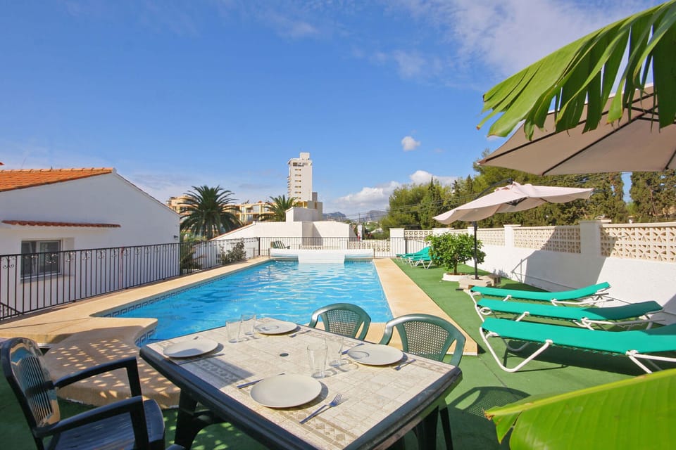 Pleasant summer villa with private pool located in Calpe (Costa Blanca) for 12 people, with six bedrooms and four bathrooms distributed over two floors.INTERIOR: This villa is composed of the GROUND FLOOR which consists of a living room with Sat / DTT TV, air conditioning, breakfast bar and access to the terrace and pool. A fully equipped kitchen with dishwasher and hob. Two bedrooms with a double bed each. In addition there is a bathroom with shower. The UPPER FLOOR consists of three bedrooms with two single beds each, two of them with a bathroom with shower en suite. A bedroom with a double bed and finally a room with a washing machine. All bedrooms and the living room have air conditioning.EXTERIOR: A large 10x5 pool and fenced for child insurance with Roman stairs and outdoor shower. There is also a construction barbecue and parking for 4 vehicles on the same plot.DISTANCES: Without a doubt, an unbeatable location; Only 200 m away is the nearest supermarket and restaurants. The sandy beach is accessible only 650 m away with all services. There is also a cove 400 meters away and the center of Calpe is 3 km away.OBSERVATIONS: Free WiFi. Pets are allowed up to 12 kg with supplement.