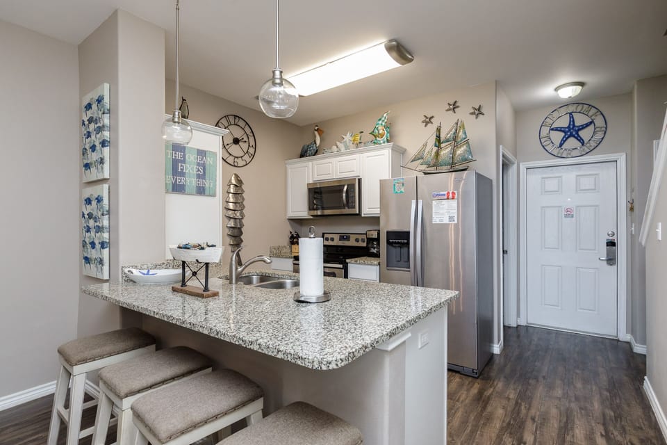 Your fully equipped kitchen awaits with granite countertops and nautical charm, perfect for preparing meals while enjoying coastal décor.