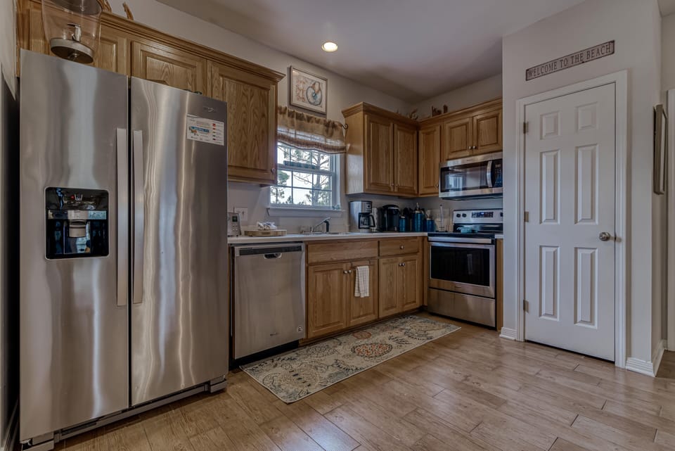 Kitchen - The large, spacious kitchen offers stainless appliances which include a dishwasher, built in microwave, stove with smooth cooktop and a side by side refrigerator.