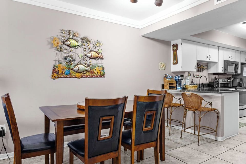Dining/Kitchen - The open dining area features a table with seating and additional seats are offered at the adjacent bar.