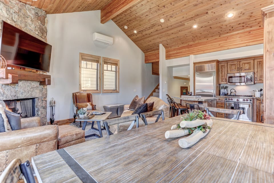 Living room with fireplace, 55" HD Smart TV, dining area and private deck