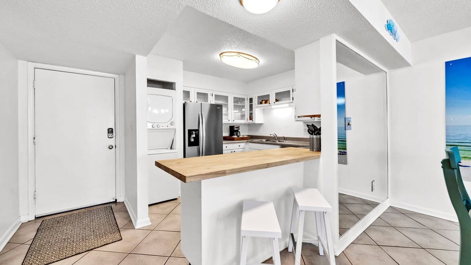 Kitchen With Bar Seating For Two and Stackable Washer and Dryer