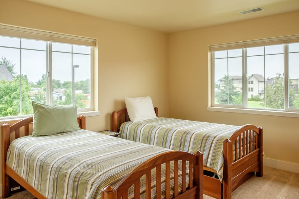 Natural light highlights the cozy twin beds in this upstairs bedroom.