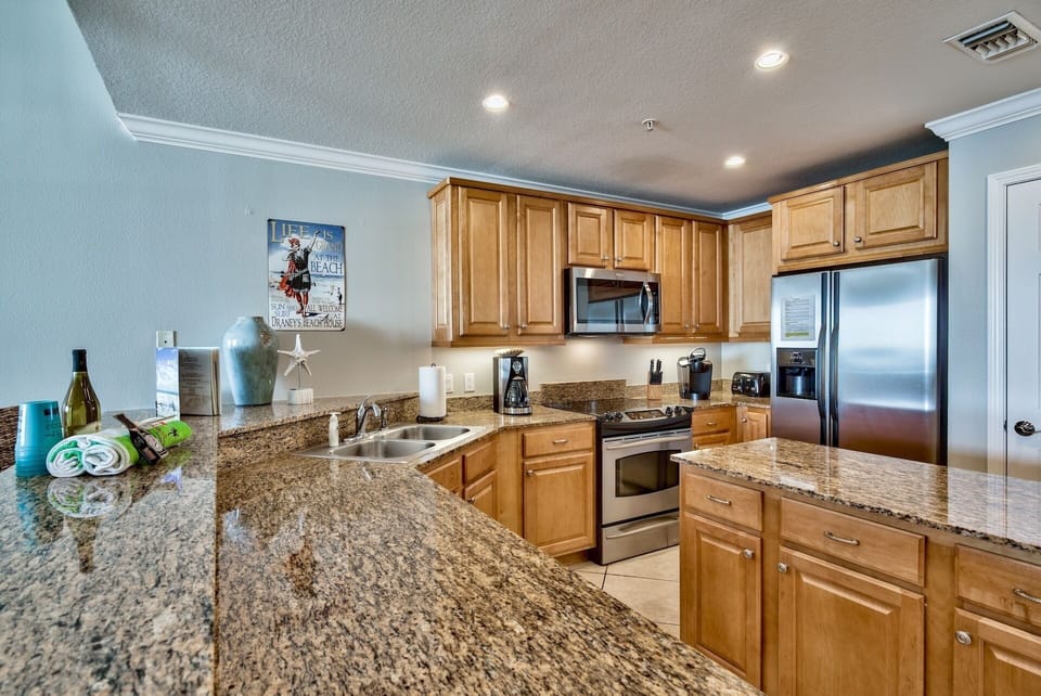 Well-stocked kitchen in San Remo 402 - Spacious kitchen with an island for meal preparation. You will find that your friend at the beach has supplied the kitchen with everything from crock pot to shrimp boil pot.