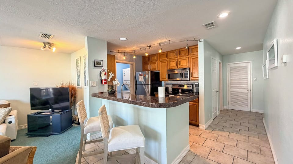 Your open-concept living flows seamlessly into a fully equipped kitchen with granite counters, perfect for cooking and entertaining together.