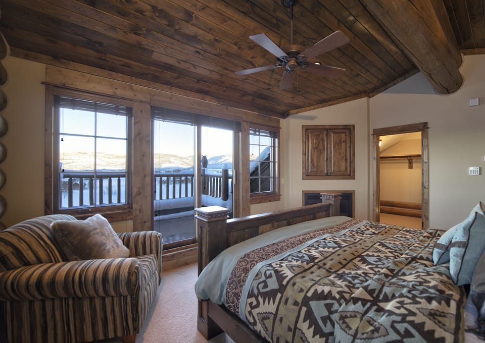 Wake up to breathtaking mountain vistas from your cozy bedroom, where rustic wood beams and warm textures create the perfect alpine retreat for your mountain getaway.