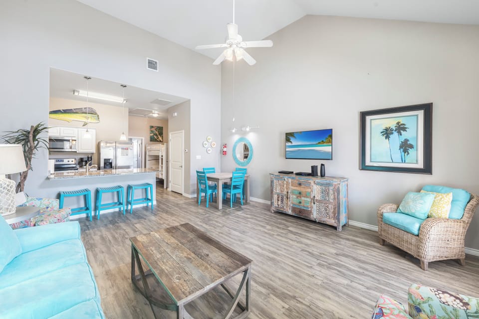 Relax in your bright, coastal-themed living space where beach blues and tropical touches create the perfect vacation vibe.