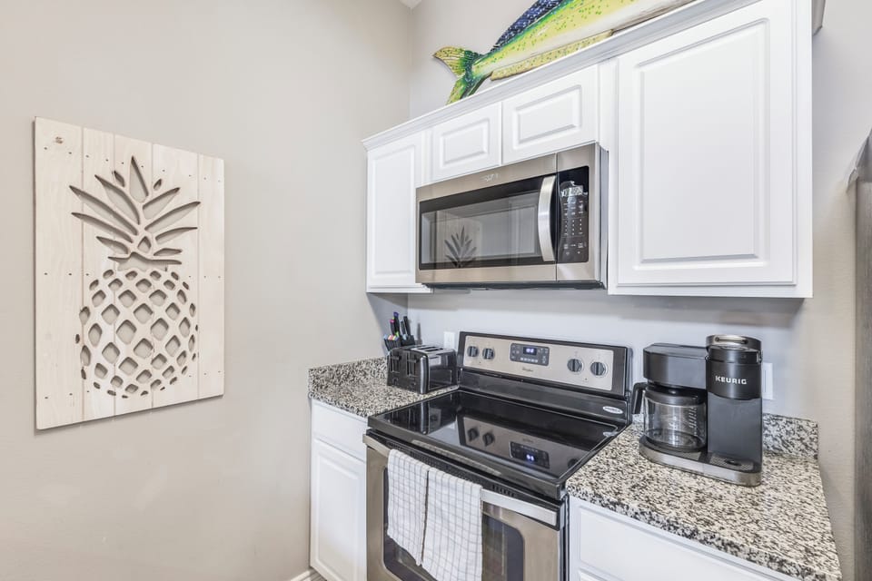 Your fully equipped kitchen features granite countertops, stainless steel appliances, and cheerful pineapple décor to make cooking feel like a tropical getaway.