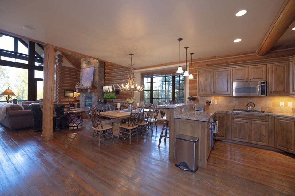 Step into your rustic mountain retreat where warm wood beams and a crackling stone fireplace create the perfect atmosphere for memorable meals and cozy evenings with loved ones.