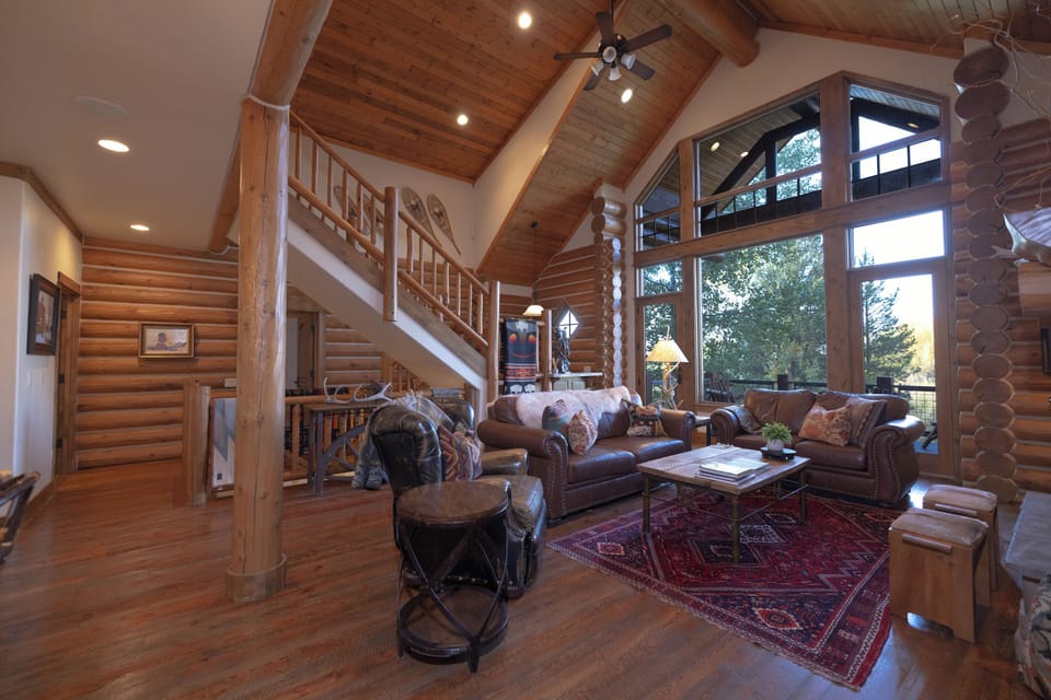 Step into your rustic mountain retreat where soaring wood ceilings and exposed beams create an inviting great room. Sink into plush leather seating by the windows and watch nature unfold outside.