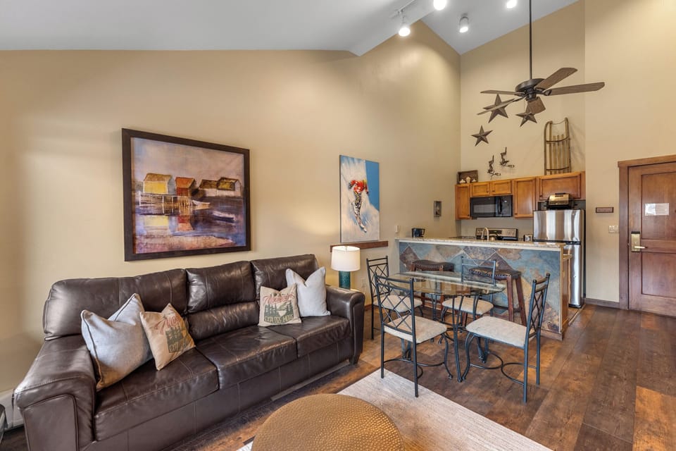 Relax on the plush leather sofa while savoring meals at your stylish dining table in this beautifully appointed open-concept space.
