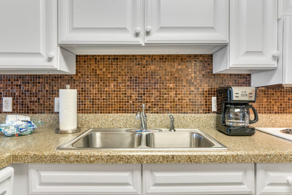 Kitchen - This fully stocked kitchen features both small and large appliances. Each cabinet and drawer is fully stocked with items for meal prepping during your stay.