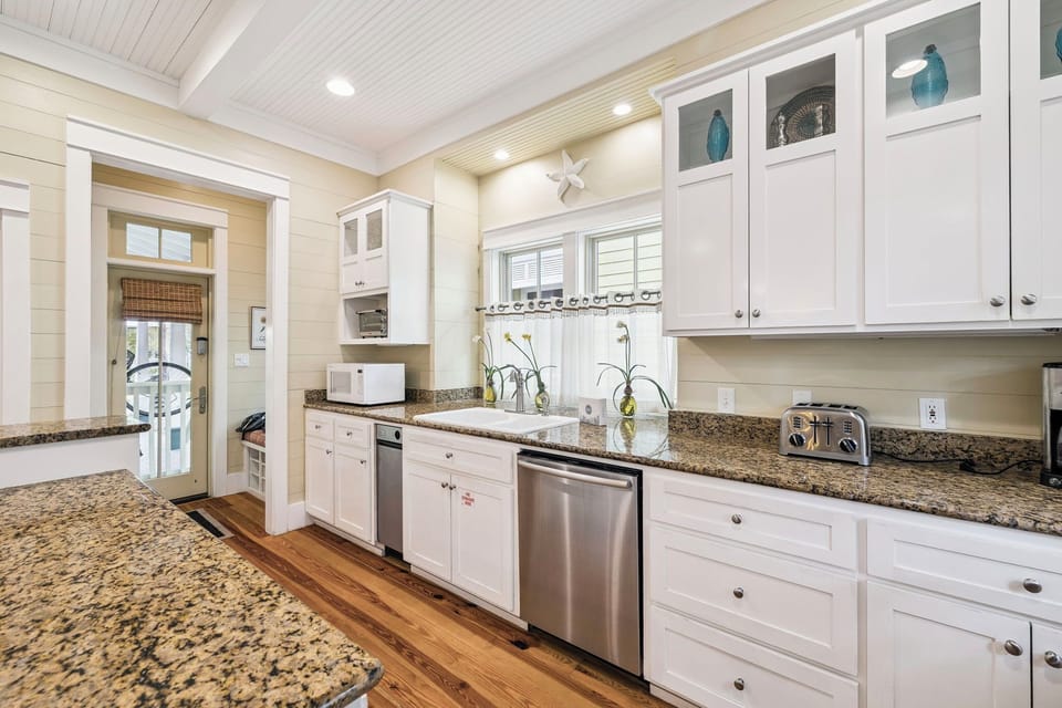 Cook your favorite meals in this bright, fully-equipped kitchen featuring granite countertops, stainless steel appliances, and charming coastal touches.