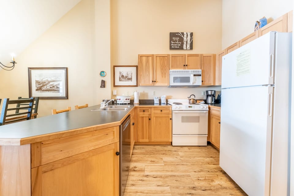 Full size kitchen with vaulted ceilings and hardwood flooring.