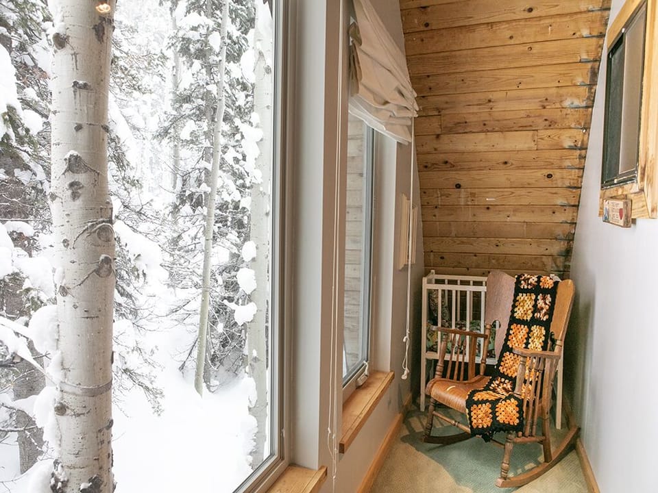 Downstairs Mud Room - Downstairs mud room with outdoor view, rocking chair and crib.