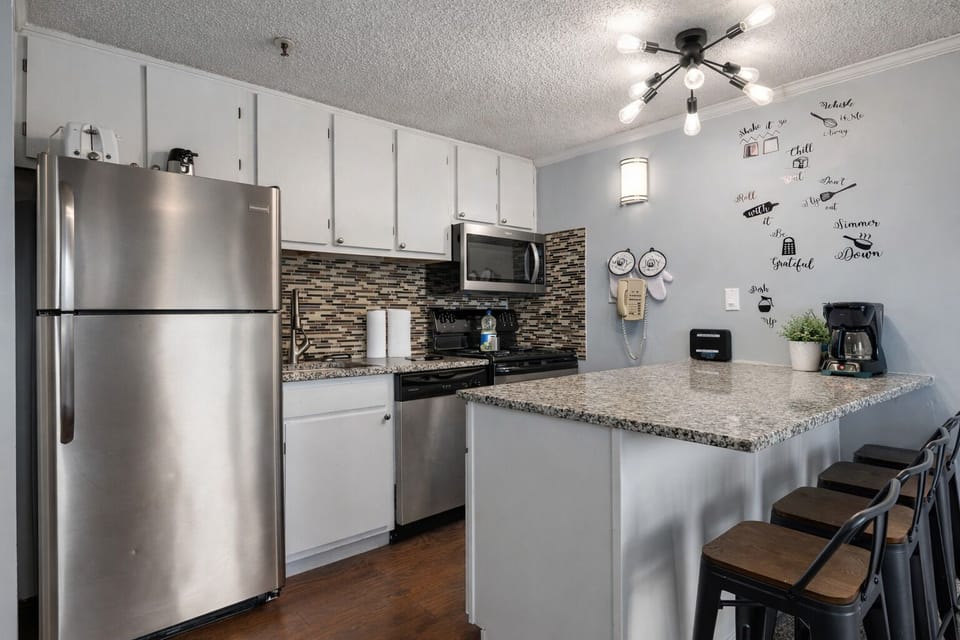 Featuring a fully equipped kitchen island with 4 high bar stools