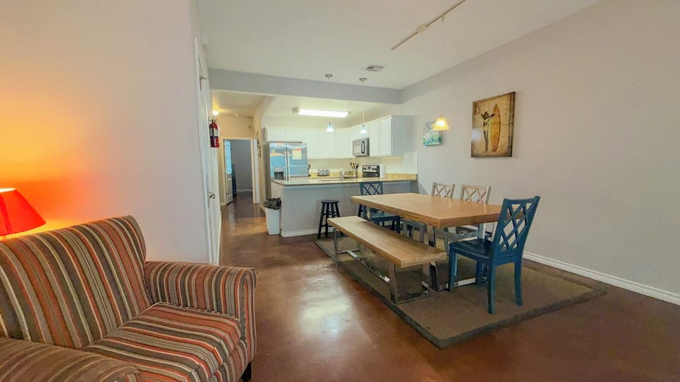 Relax in your open-concept living space where cozy striped seating flows seamlessly into a modern dining area and fully-equipped kitchen.