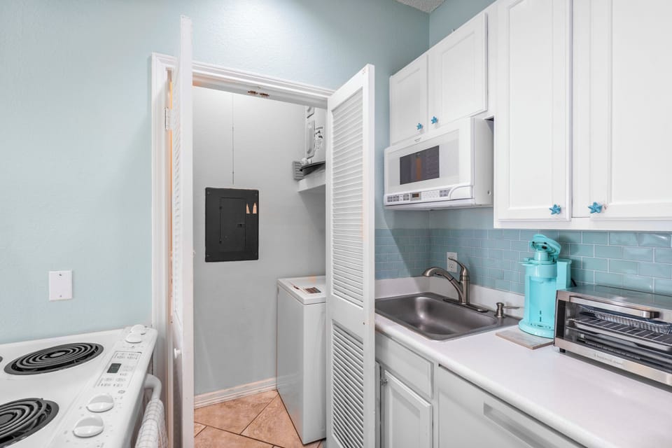 Your fully equipped kitchen features everything you need, with a convenient washer and dryer tucked away behind charming louvered doors.