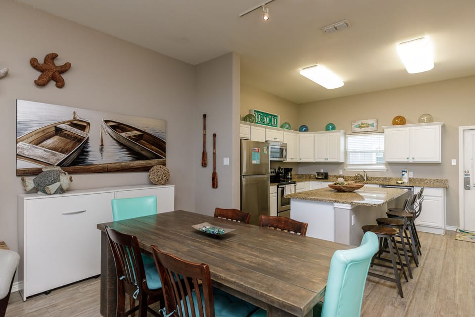 Gather around your spacious dining table while coastal art and nautical touches create the perfect beach house atmosphere.