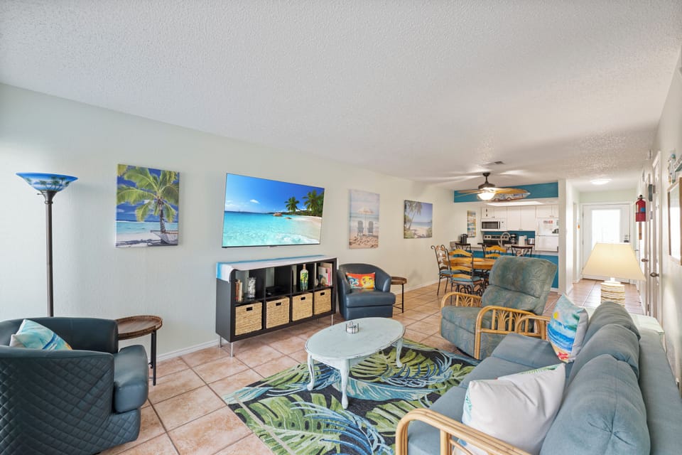 Your bright, tropical-themed living space features comfortable seating and coastal artwork, perfect for unwinding after beach adventures.
