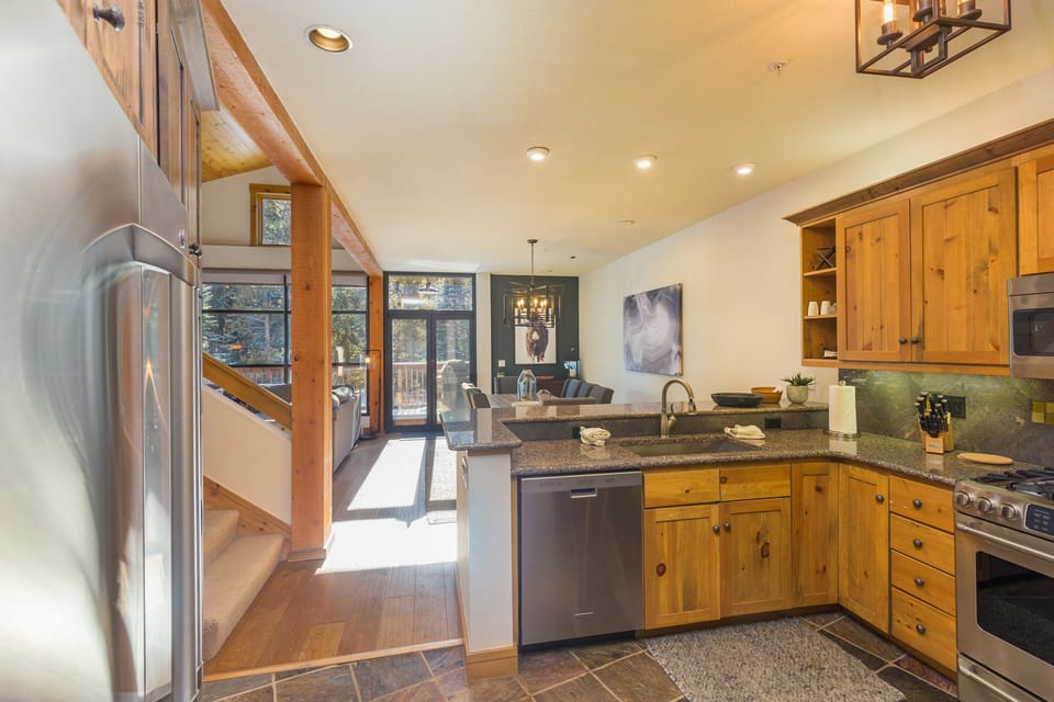 Your fully-equipped kitchen awaits with warm wood cabinets, granite counters, and stainless steel appliances - perfect for creating memorable meals together.