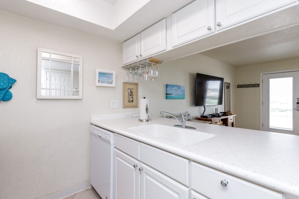 Your fully equipped kitchen features pristine white counters, ample storage, and everything you need to prepare delicious meals during your stay.