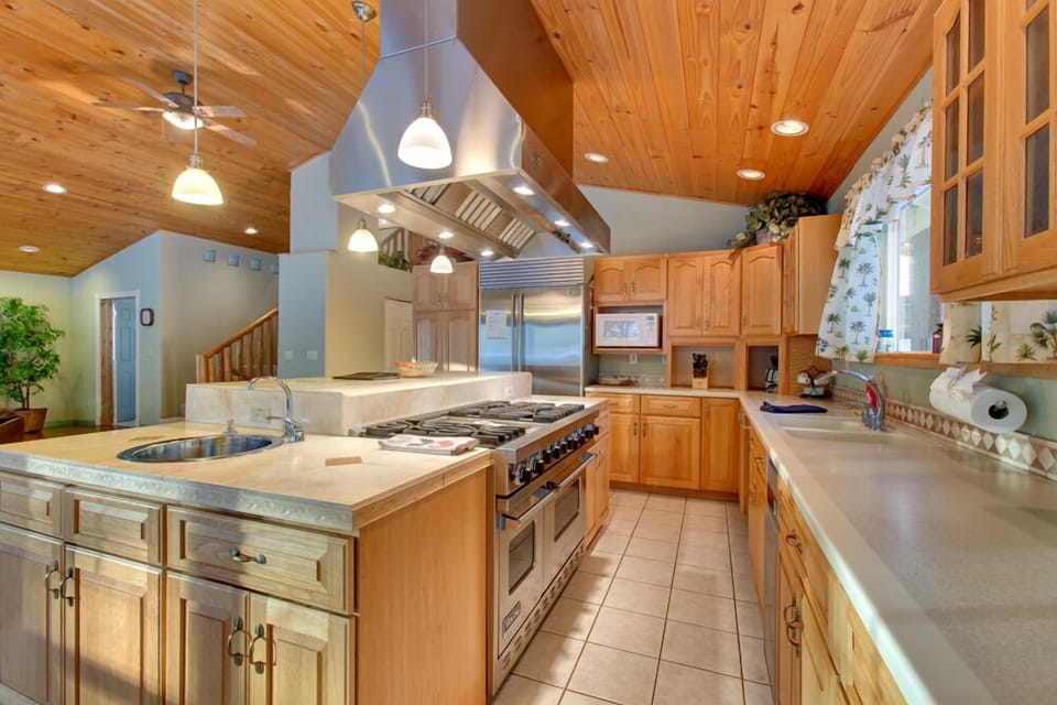 A well-equipped kitchen with stainless steel appliances, a large island, and plenty of prep space.