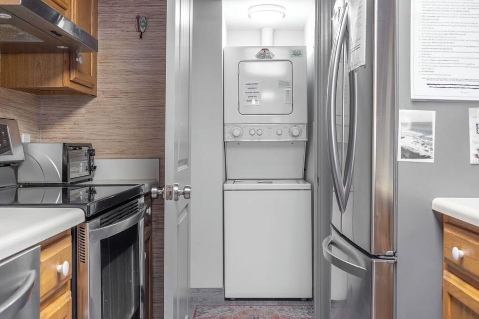 Kitchen - A well-equipped kitchen featuring modern appliances, fully stocked with dishes, and the added convenience of a stackable washer and dryer for use during your stay.