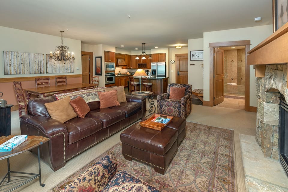 Sink into this inviting living room where leather seating and a crackling fireplace create your perfect mountain retreat atmosphere.
