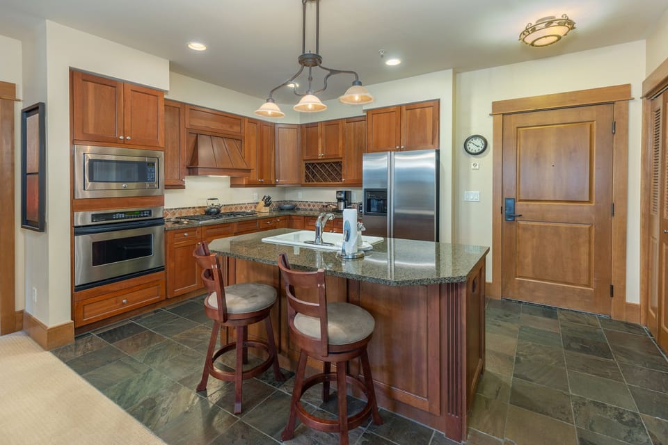 Prepare your favorite meals in this gorgeous kitchen featuring rich wood cabinets, granite counters, and top-tier stainless appliances.