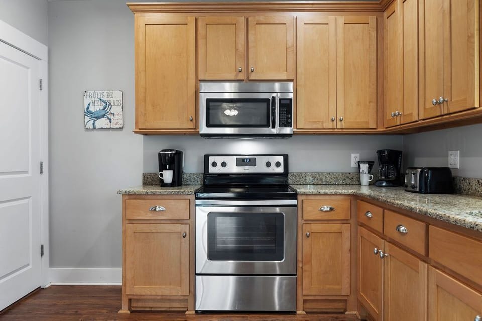Kitchen - The spacious kitchen features stainless appliances which include a smooth cooktop stove and built in microwave. Small appliances are also provided which include both regular and k-cup coffee makers for ease of enjoying your morning cup of joe.