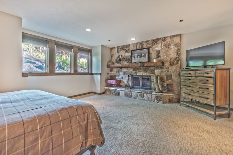 Lower Level Master Bedroom with King Bed, Smart TV, Wood Fireplace and Private Bath with a Tile Shower