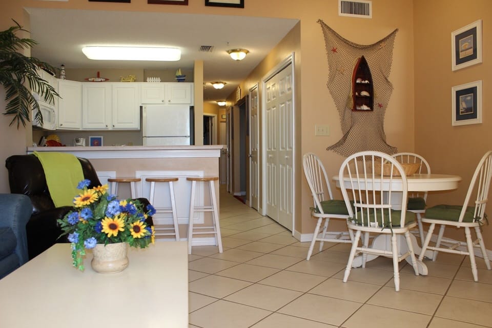 Dunes 303 - The living room, dining room table, kitchen and hallway.