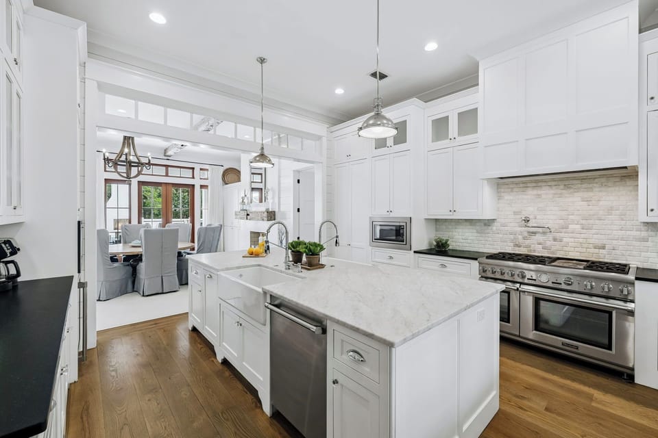This bright, open kitchen invites you to gather and create. White cabinetry and marble counters offer ample prep space, while professional-grade appliances make every meal effortless and enjoyable.