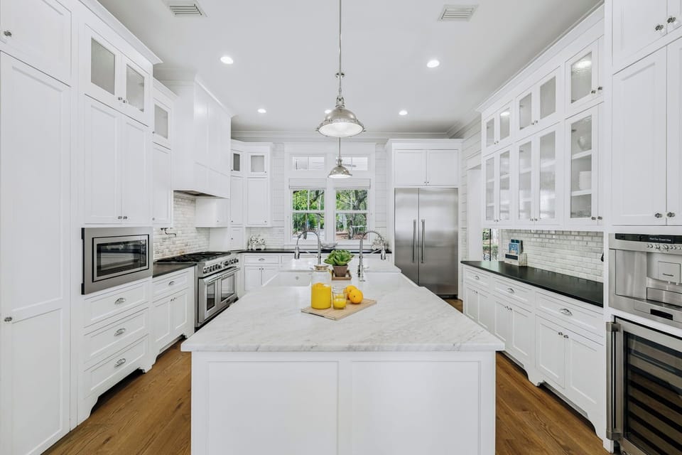 Your gourmet kitchen awaits—gleaming white cabinetry, marble island, and top-tier appliances invite you to cook, gather, and create memories in elegant style.