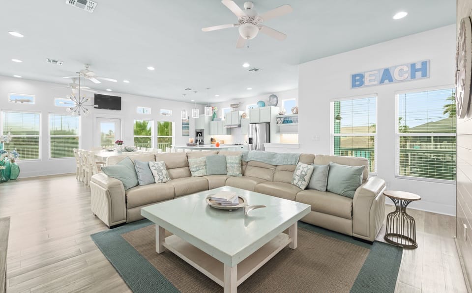 Main Living — Tan Leather Sectional, Starfish Pillows, BEACH Sign & Sputnik Chandelier