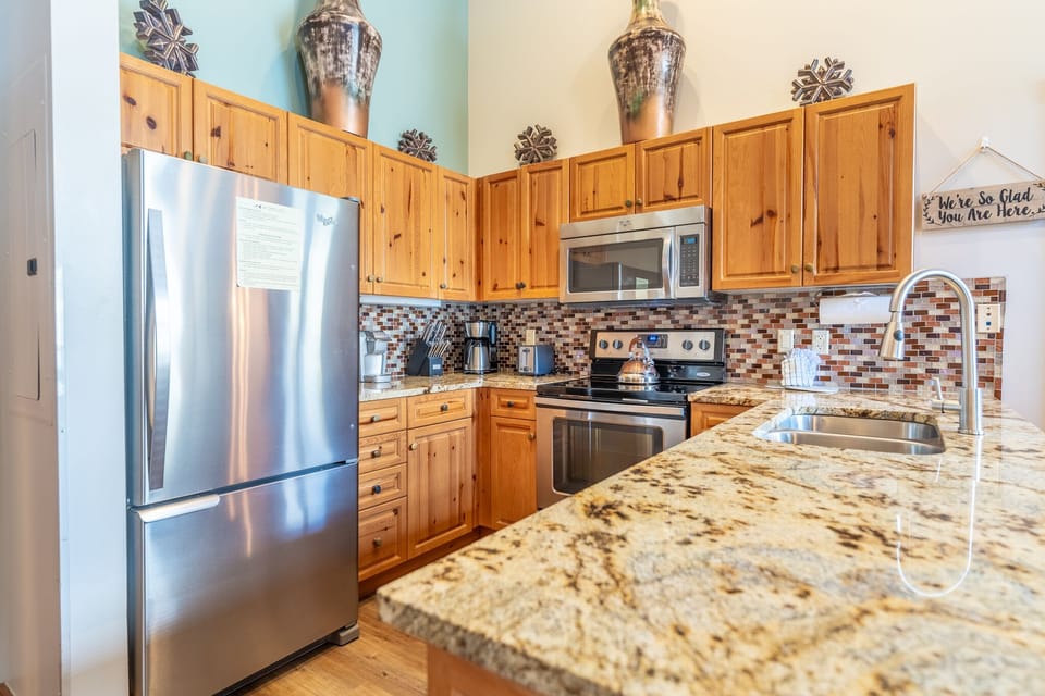 Your fully equipped kitchen awaits with granite counters, stainless appliances, and warm wood cabinets - perfect for creating memorable meals together.