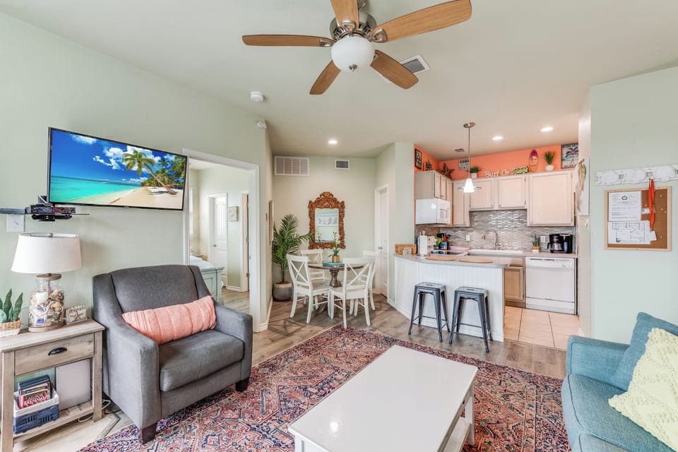 Relax in your bright, open living space where modern comfort meets coastal charm with kitchen island seating and cozy furnishings.