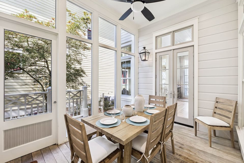 Enjoy intimate meals in your bright screened porch, where natural light streams through floor-to-ceiling windows and gentle breezes keep you comfortable.